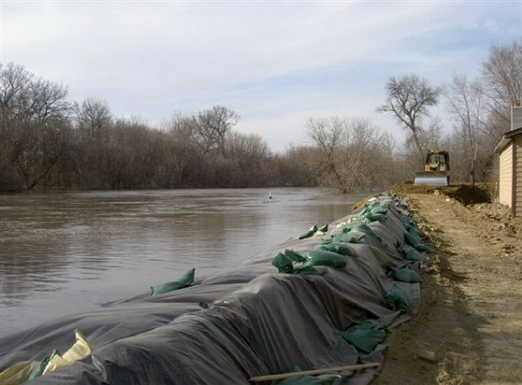 sandbags line up along the river bank