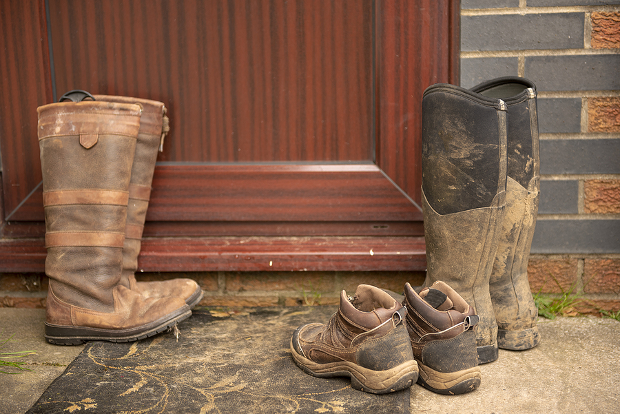 muddy boots on a mat by the front door