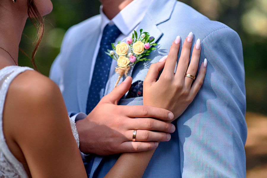 a woman and man touch hands with wedding rings