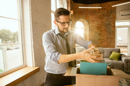 man packs an exit box to leave workplace