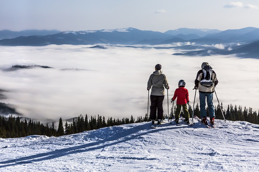 two adults and child survey mountain scene