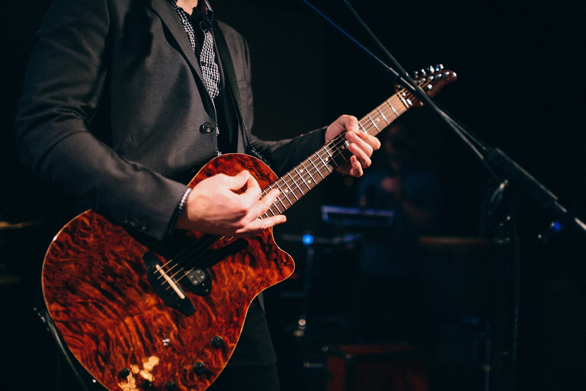 man playing guitar by grand piano